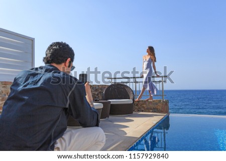 Beautiful couple taking picture at a hotel resort with a sea view