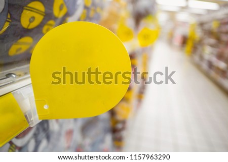 Mock up blank yellow discount tag on the products shelves in supermarket