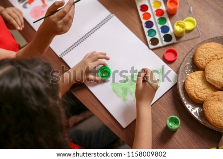Little child painting picture at home. Christmas celebration
