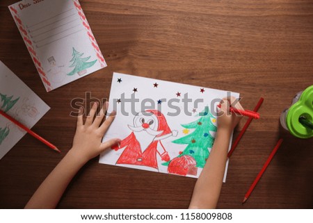 Little child drawing picture at table, top view. Christmas celebration