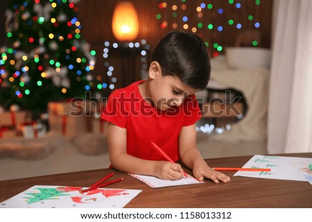 Little child writing letter to Santa at home. Christmas celebration