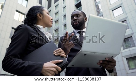 Afro-American businessman giving instructions to assistant, working on project Royalty-Free Stock Photo #1158038107