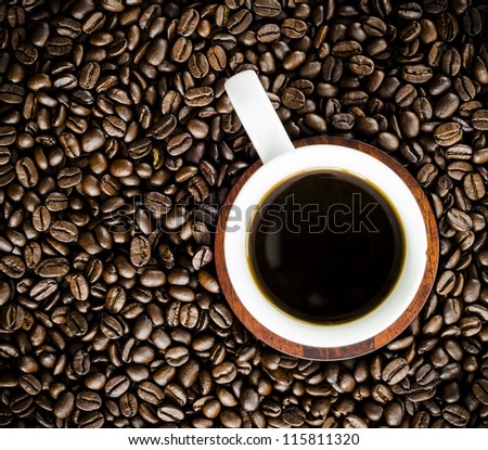 Cup of coffee on a bed of coffee beans
