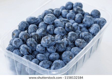Close up of blueberries in a container on white background