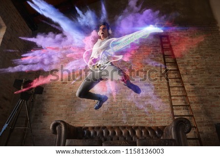 man jumps with colorful background playing a virtual guitar. concept of freedom and creativity with music
 Royalty-Free Stock Photo #1158136003
