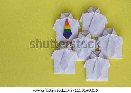 LGBT symbol of rainbow flag on tie. Figures of people, shirt made of paper, origami. Protection of the rights of homosexuals, tolerance. Public opinion. Stand out from the crowd. Gays, transgender.