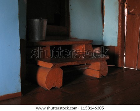 Russian province, the picture of village life. Old log staircase to the storeroom, painted with red paint, in a wooden country house