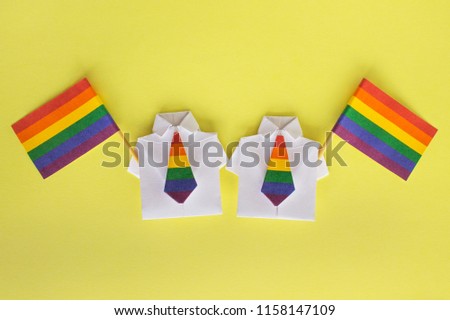 LGBT flags and figures of people. Shirt made of paper with colour tie, origami. Minorities, family. Rights of homosexual, gays, transgender and other. Tolerance.