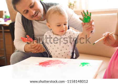 Mother and father drawing together with their child