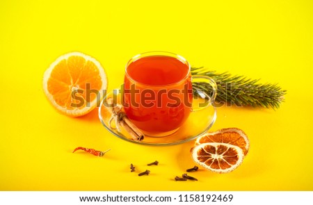 mulled wine hot drink on a bright background next to lie fruit and spices