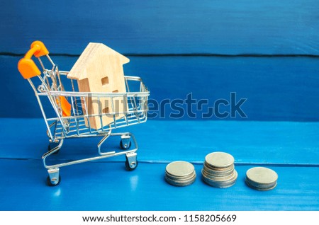Property investment and house mortgage financial concept. buying, renting and selling apartments. real estate. Wooden house in a Supermarket trolley. credit, affordable housing for young families.