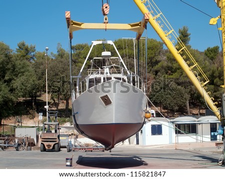 fishing boat on repair in dry dock Royalty-Free Stock Photo #115821847