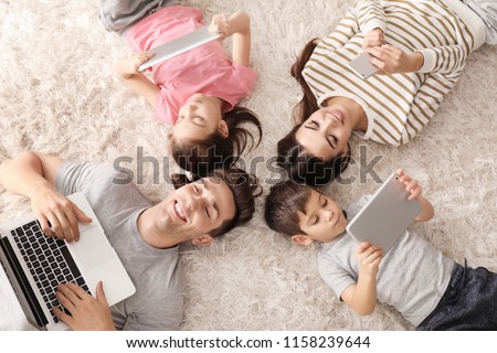 Young family with gadgets at home, top view Royalty-Free Stock Photo #1158239644