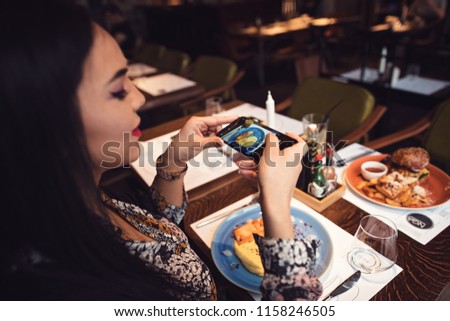 Urban girl out in town at a cool food bar for drinks and lunch eating tasty food and drinking fresh lemonade. Girl waiting for friend to make important announcement getting excited to hear new secret