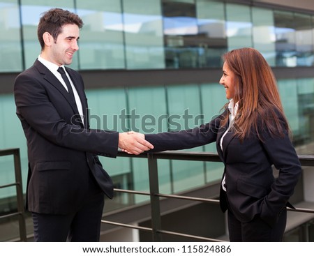 Handshake between businessman and businesswoman at modern office