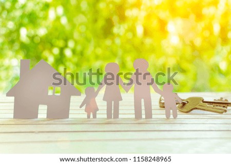 Real estate. Paper family on wooden table with garden bokeh outdoor theme background. 