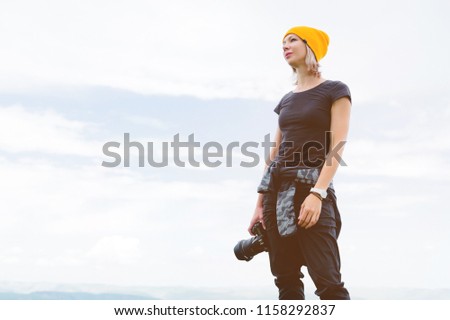 Photographer holding a camera outdoors. Girl on nature