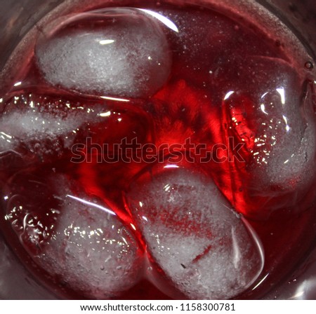 A bird's eye, close up view of a chilled glass of red carbonated soda. This photo was taken in Brisbane, Australia. 