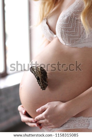 pregnant girl with a butterfly on a stomach
