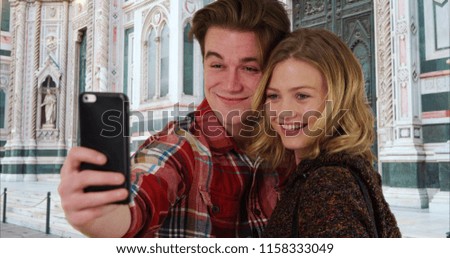 Cheerful young taking a selfie in front of Florence Cathedral smiling