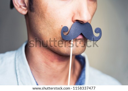 close up of a man's chin wearing a fake paper made mustache Royalty-Free Stock Photo #1158337477