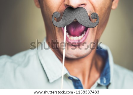 close up of a joyful man's chin wearing a fake paper made mustache Royalty-Free Stock Photo #1158337483