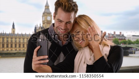 Newly engaged couple take a selfie in London to share the news with friends