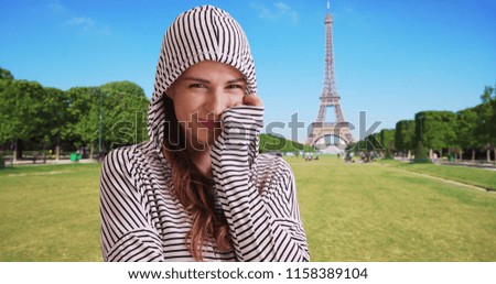 Happy Caucasian female smiling at camera in Paris near Eiffel Tower