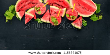 Watermelon juice with mint and ice in a glass. Melon. On a black wooden background. Free space for text. Top view.
