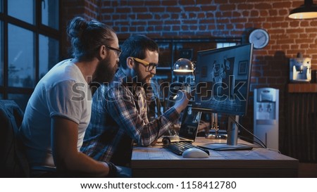 Side view of diverse group of men sitting at table with computer and coworking on creation of new cartoon movie Royalty-Free Stock Photo #1158412780