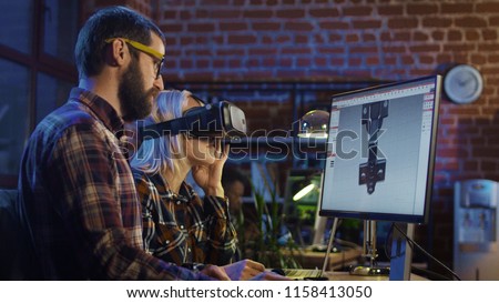 Woman in VR glasses and man sitting at computer and creating graphics of modern video game Royalty-Free Stock Photo #1158413050
