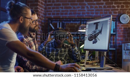 Group of diverse men using VR technology and developing modern visual effects for videogame and computing Royalty-Free Stock Photo #1158413056