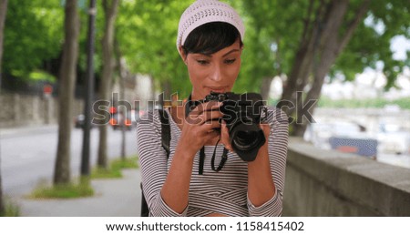 Portrait of black photographer taking photos outside in city setting