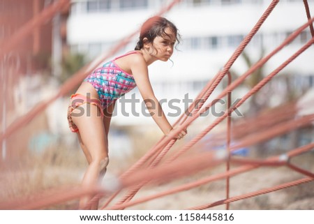 Girl 6 years old on a rope attraction on the beach