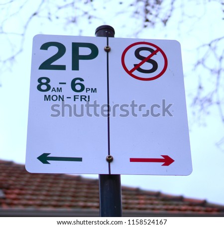Close up view of two hour parking limit and no standing sign in white red and green