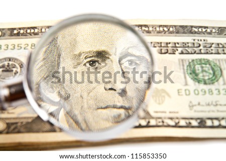 dollars and magnifying glass on a white background