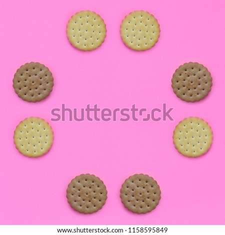 Frame of a brown biscuits on a pink background. Trendy minimal concept of food and dessert. Abstract flat lay, top view