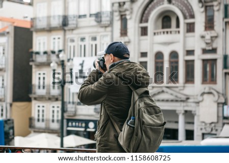 A professional travel photographer or tourist photographs a beautiful urban landscape in Porto in Portugal. Professional photography or interesting hobby.