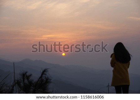 Back View of A Chinese Woman Standing on the Mountain Watching the Sunrise