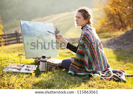 Young artist painting an autumn landscape Royalty-Free Stock Photo #115863061