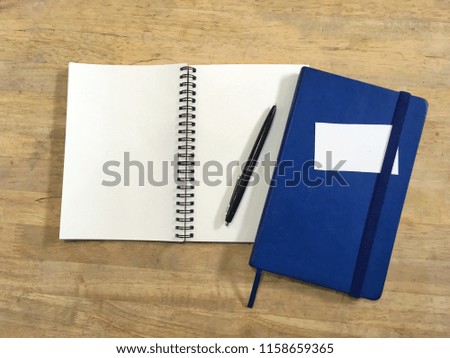 Daiary and note book with name card and pen on wooden table