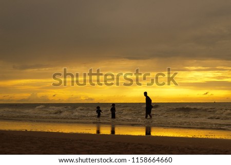 Pictures of two father and son walking in the sea and keeping the atmosphere of the morning sun.