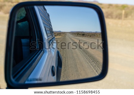 empty road in the desert - view in the car mirror namibia