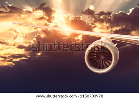 Airplane engine on the rainy cloudy sky background. The sun's rays make their way through the clouds. 