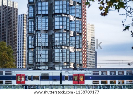 Graphic landscape close up view over parts of modern buildings details, with window mirrors reflecting sun light, fast RER suburb train passing by, blue sky in background, Paris, France, Europe.