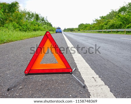 Red warning triangle on the road sign with a broken car.