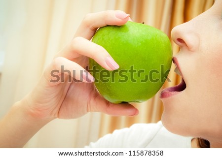closeup photo of a woman eating green apple