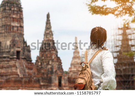Asian woman tourist with backpack is taking a photo or selfie with smartphone during a travel and relax in holiday at Wat Chai Watthanaram temple in ayutthaya Thailand
