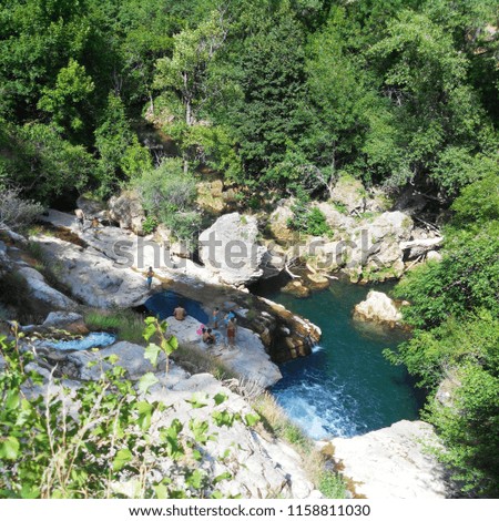 Beautiful view of mountain river with waterfall in the summer sunny day 