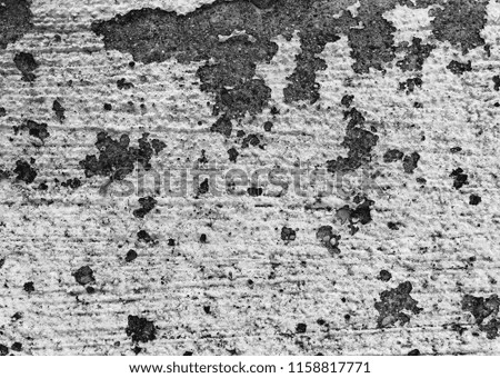 Grunge background texture in black and white, rough cement concrete surface with dirty stained peeling paint and pitted grungy spots